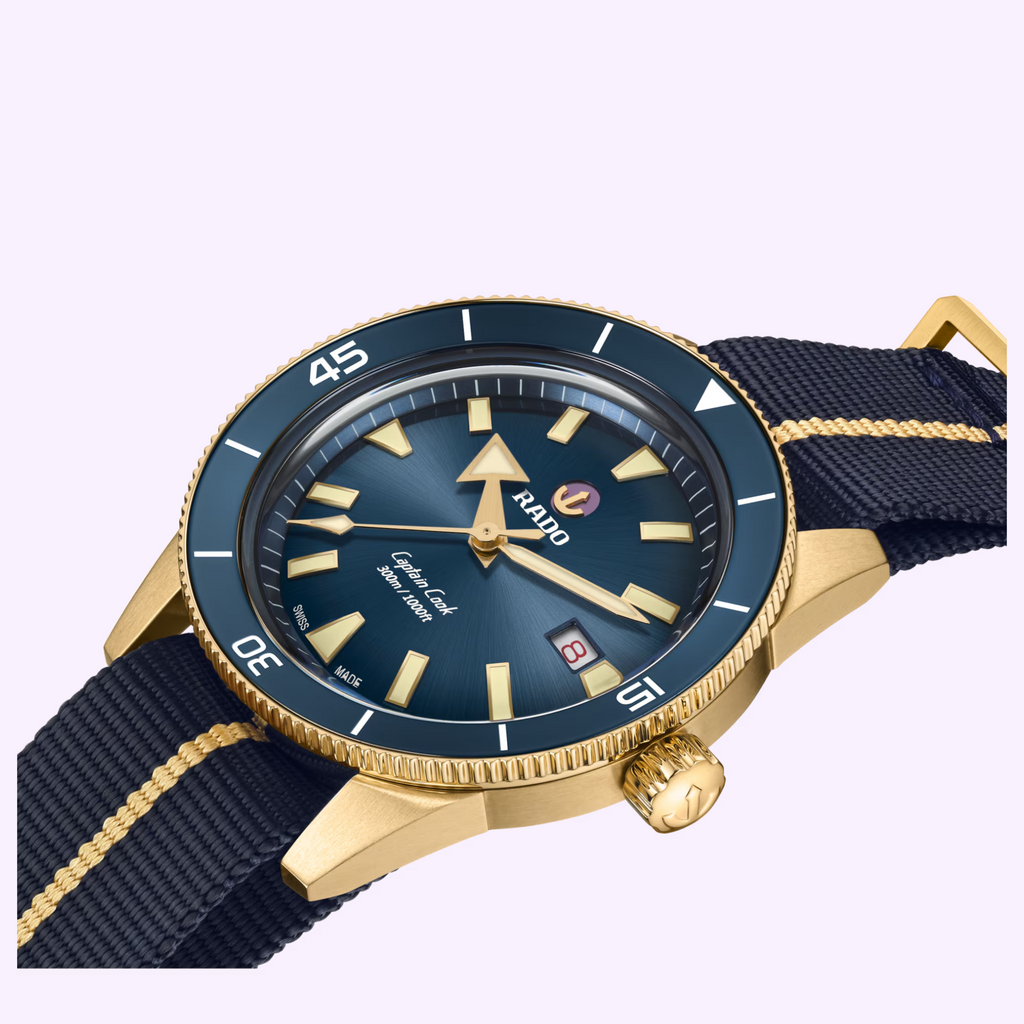 Rado Captain Cook Bronze R32504208 on navy NATO-style strap with gold stripe