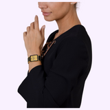 A woman wearing a gold and black Rado Watches Integral Limited Edition R20254702 watch with a gold dial on her wrist.