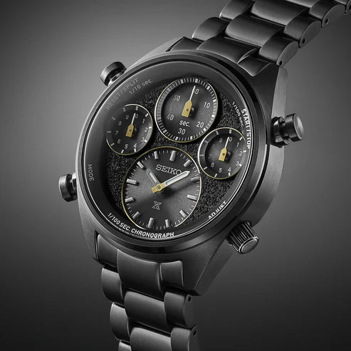 A close-up of the Seiko Watches Chronograph Solar SFJ007 by Seiko Watches, featuring a black metal band and case, three subdials, yellow-accented hands, and a textured face set against a gradient gray background.