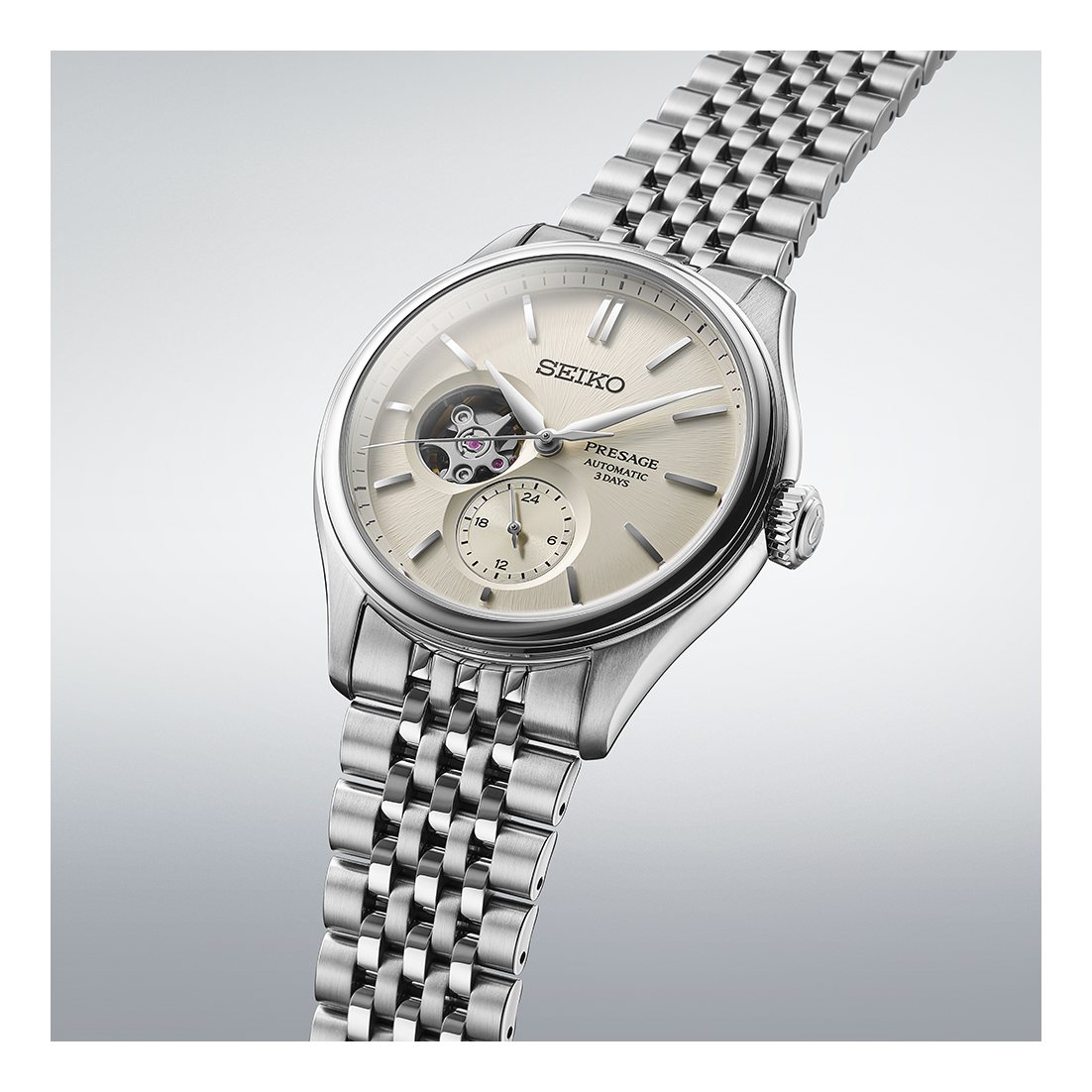 The Seiko Luxe Watches Presage Classic Series SPB469 features an automatic movement, open-heart dial, small seconds subdial, silver hour markers, and a stainless steel bracelet, shown on a light gradient background.