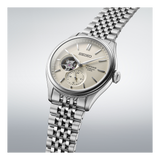 The Seiko Luxe Watches Presage Classic Series SPB469 features an automatic movement, open-heart dial, small seconds subdial, silver hour markers, and a stainless steel bracelet, shown on a light gradient background.