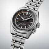 A close-up of the Seiko Luxe Watches PROSPEX SPEEDTIMER MECHANICAL SPB515 with a stainless steel band, black textured dial, orange accents, date display, and silver hour markers, photographed at an angle on a light background.