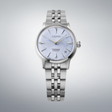 The Seiko Luxe Watches Presage Cocktail Time SRPL61 features a textured light blue dial, gold second hand, and stainless steel bracelet, shown on a light gray gradient background.