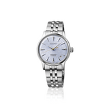 The Seiko Luxe Watches Presage Cocktail Time SRPL61 features a textured light blue dial, silver markers and hands, date at 3 o’clock, and a stainless steel bracelet, shown on a white background.