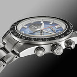 A close-up side view of the Seiko Watches Speedtimer Solar Chronograph SSC931 with a stainless steel band, blue dial, and tachymeter bezel, set against a gradient gray background.