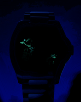 A Lexor Miami Mido Watch M852.018.730 Day of the Dead illuminates the darkness with its striking dial, adorned with glowing, luminescent artwork depicting a dinosaur skeleton and a small mechanical figure, capturing the intrigue of this special edition timepiece.