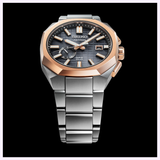 The Seiko King Watches Astron GPS SOLAR SSJ014 by Seiko Luxe Watches features a silver metal band, black dial with gold accents, and date display, showcased against a black background.