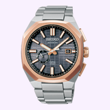 The Seiko King Watches Astron GPS SOLAR SSJ014 by Seiko Luxe Watches features a silver metal band, gray textured dial, and gold-tone bezel with gold accents on indices and hands.