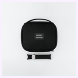 A black zippered Seiko King Watches Astron HAB005 carrying case positioned above a black rubber watch strap with a metal clasp.