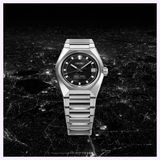 Silver-tone stainless steel Seiko King Watches King Seiko VANAC HKF005 automatic watch with a black dial, baton indices, and a date window, set against a night cityscape.
