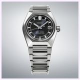 A Seiko Luxe Watches King Watches VANAC HKF003 wristwatch in silver, featuring a black dial, date display at 3 o’clock, and a metal bracelet—presented against a light gradient background as an elegant testament to Japanese watchmaking craftsmanship.