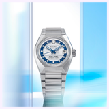 A silver Seiko Luxe Watches wristwatch—the King Watches VANAC HKF004 Limited Edition—stands upright against a soft blue and white backdrop accented with glass-like panels. This special release commemorating Seiko's 145th anniversary is celebrated for its automatic movement, seamlessly uniting classic elegance with exceptional craftsmanship.