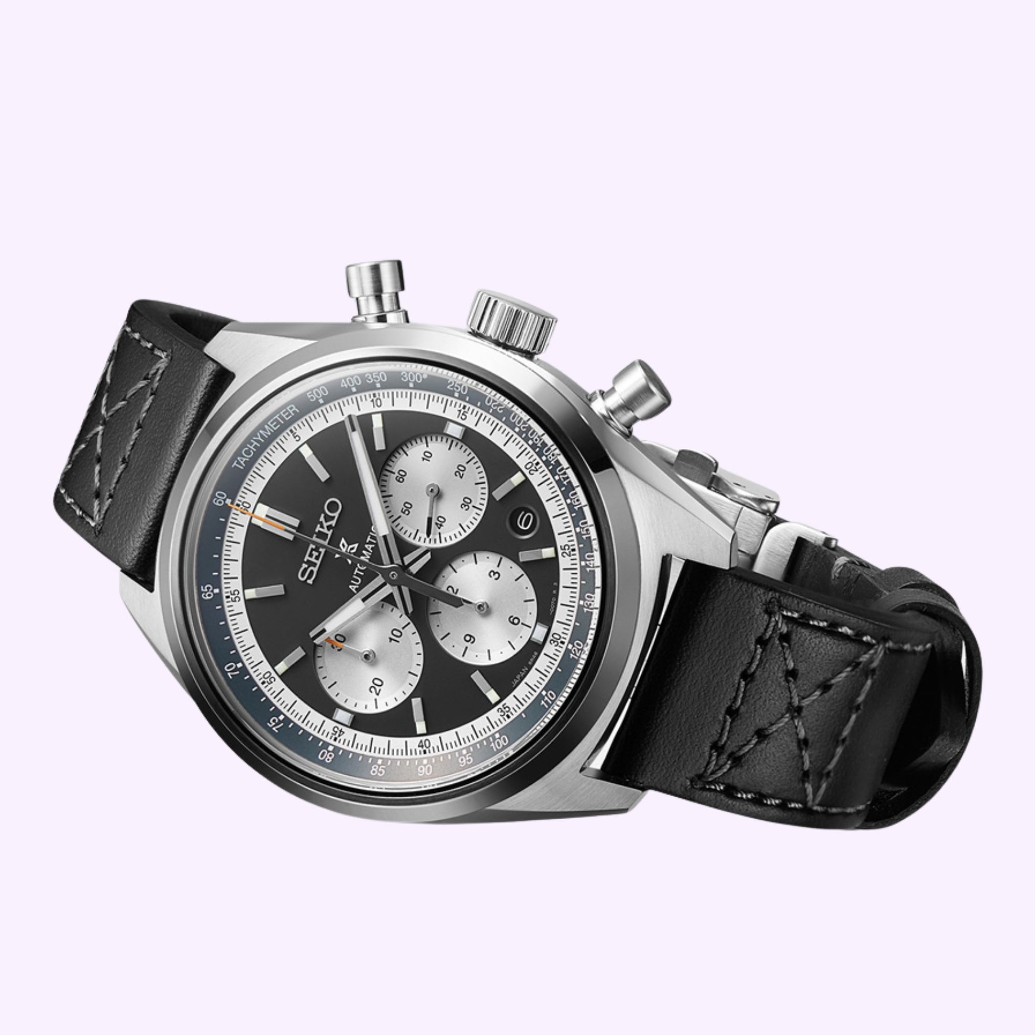 The Seiko Luxe Watches 100th Anniversary Prospex Speedtimer Mechanical Chronograph SRQ049 LIMITED EDITION, featuring a silver case, black leather strap, and black-and-silver dial with three subdials, is shown against a light purple background.