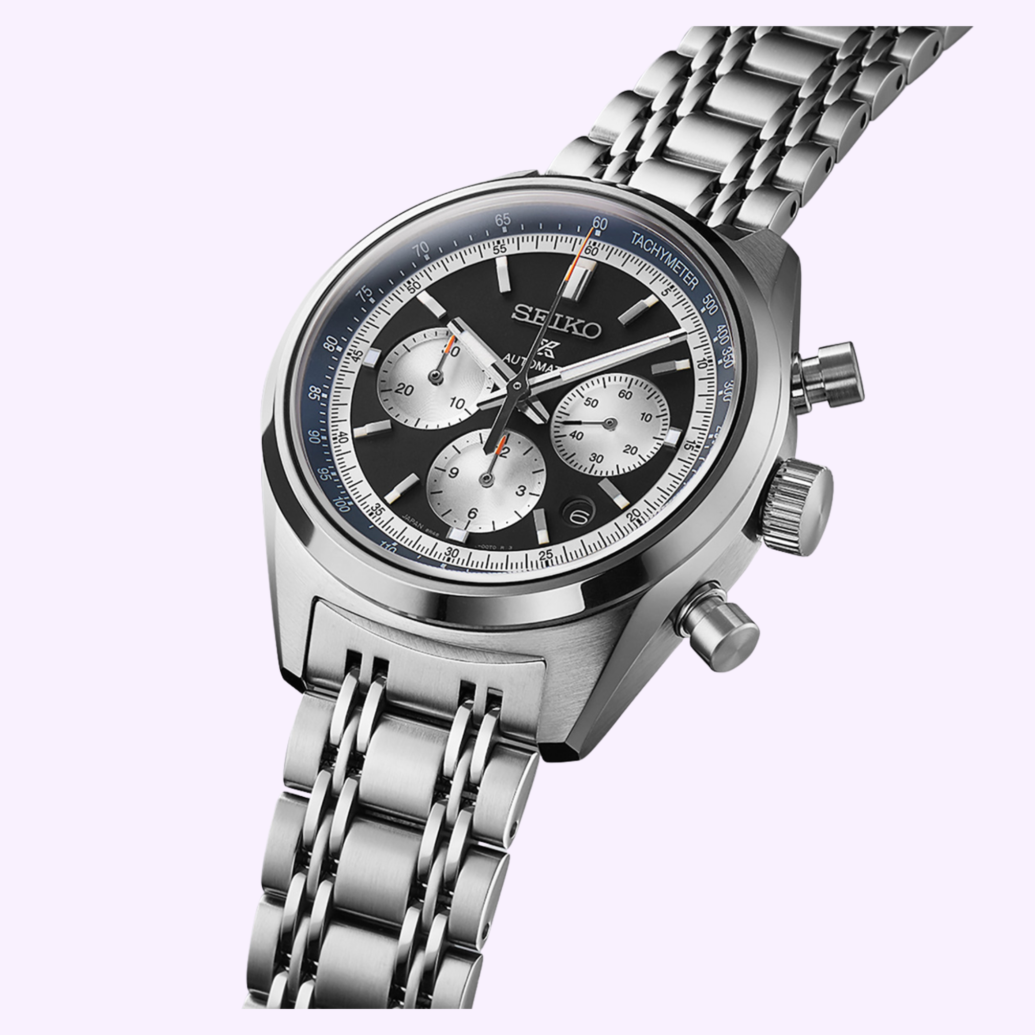 The Seiko Luxe Watches 100th Anniversary Prospex Speedtimer Mechanical Chronograph SRQ049 LIMITED EDITION features a stainless steel linked bracelet, black and silver dial with tachymeter, and three subdials, shown on a light purple background.