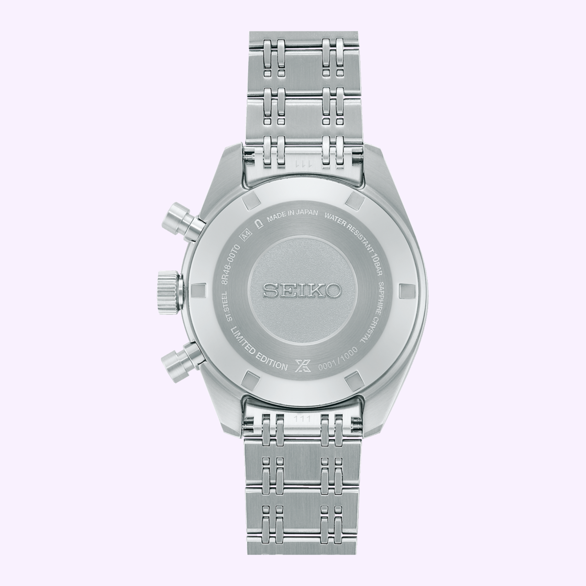 A close-up of the Seiko Luxe Watches 100th Anniversary Prospex Speedtimer Mechanical Chronograph SRQ049 LIMITED EDITION, featuring engraved caseback, two side buttons, and a metal link band on a light purple background.