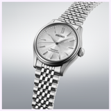 A Seiko Luxe Watches Presage Classic Series HCC001 automatic wristwatch in silver, exemplifying exceptional Japanese craftsmanship, is presented with a metallic bracelet against a light gradient background. The dial features refined patterns and minimalist hour markers.