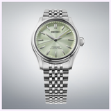 The Seiko Luxe Watches Presage Classic Series HCC002 features a light green textured dial with silver hour markers and hands, complemented by a stainless steel bracelet, shown against a light gray background.
