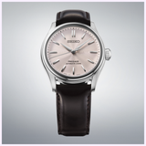 The Seiko Luxe Watches Presage Classic Series HCC003 features a delicate Sakura-iro dial, silver hour markers, and a dark brown leather strap, presented against a light grey gradient background.