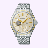 The Seiko Luxe Watches Presage Classic Series SPB480 features a silver and gold-tone case, cream dial with exposed movement at 9 o’clock, subdial at 6, and a silver bracelet—highlighting Japanese mechanical watchmaking.