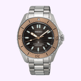 The Seiko Luxe Watches Prospex Sea SPB485 is an automatic diver watch featuring a stainless steel band, black dial, rose gold bezel, and luminous markers and hands. The face displays “SEIKO,” “AUTOMATIC 3 DAYS,” and “DIVERS 300m.”.