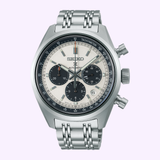 A Seiko Luxe Watches Prospex Speedtimer Mechanical Chronograph SRQ047 with a silver stainless steel bracelet, white and black dial, three subdials, and date window, shown on a light purple background.