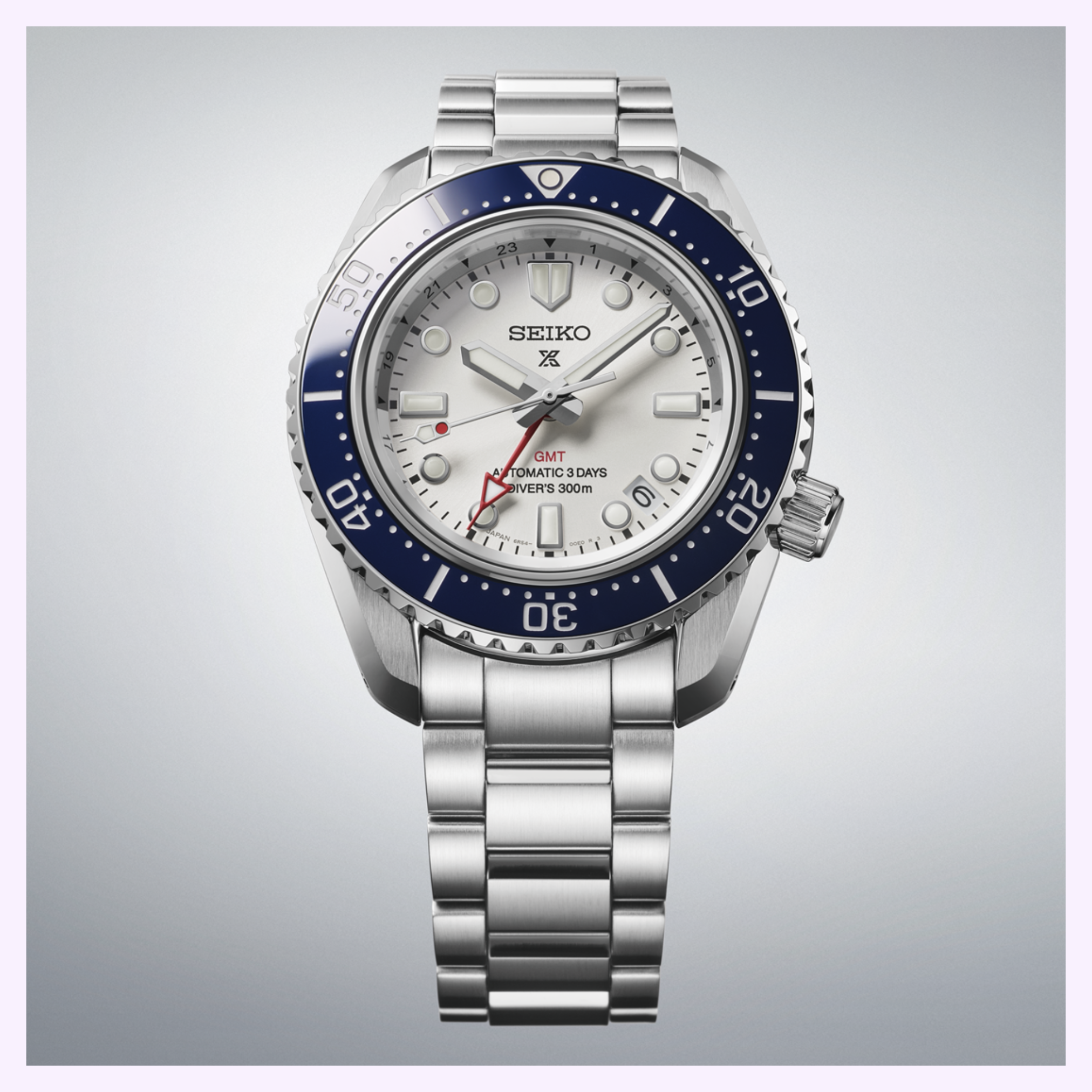 The Seiko Luxe Watches SPB519 PROSPEX HERITAGE DIVER'S GMT has a stainless steel case, white dial, blue bezel, silver markers, red GMT hand, “GMT AUTOMATIC 3 DAYS DIVERS 300m” text, and a linked metal bracelet.