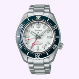 The Seiko Luxe Watches SPB519 PROSPEX HERITAGE DIVER'S GMT features a stainless steel band, silver bezel, white dial, black-and-red GMT hand, large markers, date at 4 o’clock, and 300m water resistance.