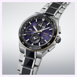 The Seiko Watches Astron HAB011J1 145th Anniversary Limited Edition, featuring a stainless steel bracelet, a striking black and purple dial with three subdials and gold accents, is showcased against a soft gradient backdrop.