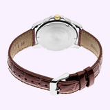 The Seiko Watches Essentials SUR360, a men’s quartz watch with a brown leather strap, silver case, and gold crown, is displayed from the back against a light purple background. This timepiece by Seiko Watches combines classic elegance with contemporary design elements.