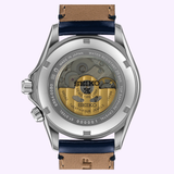 The Seiko Luxe Watches Prospex Alpinist GMT SPB377 features a transparent case back that showcases its automatic movement, labeled with Seiko and Twenty-Four Jewels. This distinctive mechanical sports watch is paired with a leather strap that has a tan interior and elegant navy edges.