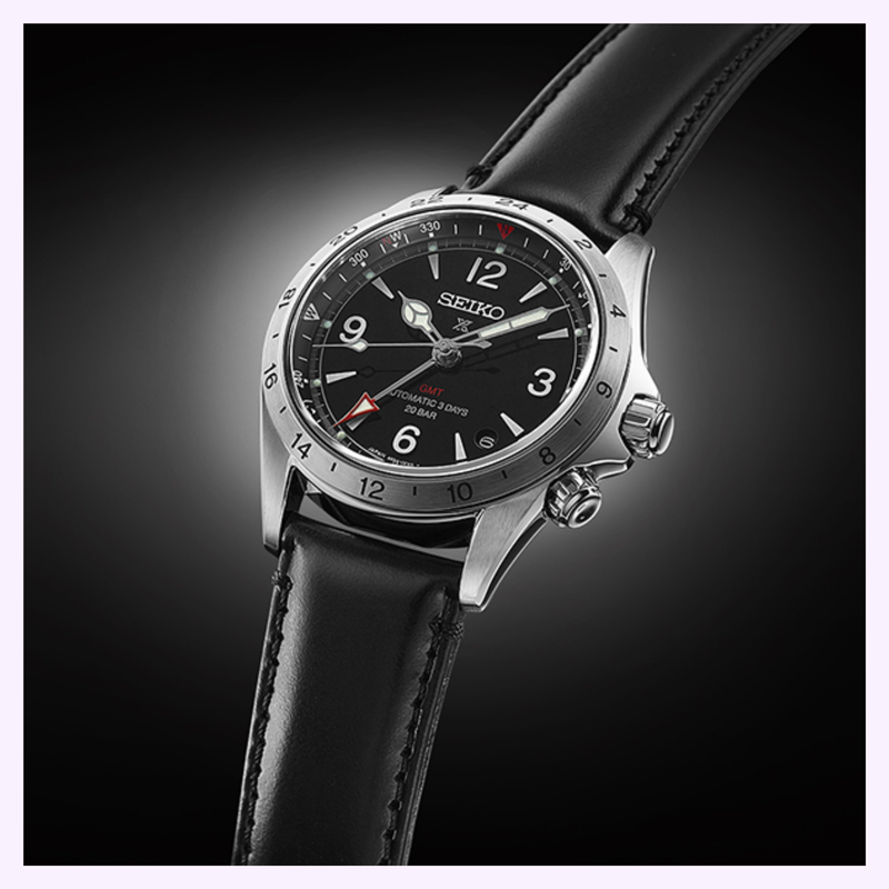 Close-up of the Seiko Prospex Alpinist GMT SPB379 black dial showing Arabic numerals, red-tipped GMT hand, and inner compass bezel
