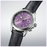 A Seiko Watches Prospex HBC006 145th Anniversary Limited Edition, featuring a striking purple dial, silver casing, and a black leather strap with purple stitching, is displayed on a light gradient background. This limited edition timepiece by Seiko Watches effortlessly merges classic design with modern sophistication.