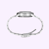 Side view of a silver Seiko Watches Presage Style60′s SSK009 wristwatch with an open metal bracelet against a light purple background. This vintage-inspired timepiece highlights the crown and clasp details, showcasing its refined mechanical GMT features.