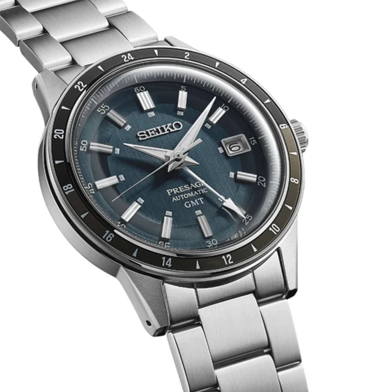 Seiko Presage Style60's SSK009 vintage-inspired silver automatic GMT watch showing the blue textured dial, silver hour markers, date window at 3 o'clock, and stainless steel bracelet