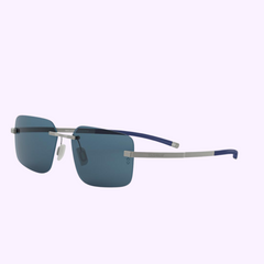 Tag Heuer Sunglasses FLEX TH40027U 5817V (UPC 192337233043) by Tag Heuer Optical—rimless, rectangular blue-tinted lenses, silver metal arms with blue tips—100% authentic, from an authorized dealer in Miami, shown on a light purple background.
