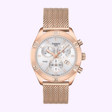 A Tissot Watches T1019173303100 PR 100 Sport Chic Chronograph, featuring a rose gold mesh band, white dial, three subdials, date display, and two side buttons, is elegantly displayed on a light pink background.