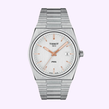 The Tissot Watches Tissot T1374101103100 PRX Stainless Steel Strap Men Watch features a silver stainless steel band, a white dial accented with rose gold hands and markers, and a date window at 3 o’clock. Elegantly displayed against a light purple background, this timepiece exemplifies Swiss watch craftsmanship for those seeking sophisticated stainless steel men’s watches.
