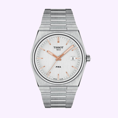 The Tissot Watches Tissot T1374101103100 PRX Stainless Steel Strap Men Watch features a silver stainless steel band, a white dial accented with rose gold hands and markers, and a date window at 3 o’clock. Elegantly displayed against a light purple background, this timepiece exemplifies Swiss watch craftsmanship for those seeking sophisticated stainless steel men’s watches.