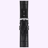 A black leather watch strap with a crocodile pattern and a silver buckle engraved with the Tissot Watches logo, designed to complement the 42mm Tissot Watches Chrono L (model T1164171605200), is displayed against a light purple background.