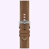 A brown leather watch strap with white stitching and a silver buckle engraved with “TISSOT” is displayed vertically on a light pink background. This elegant accessory perfectly complements the Tissot Watches Chrono L 42mm T1164171605201, known for its Swiss Quartz chronograph movement and scratch-resistant sapphire crystal.
