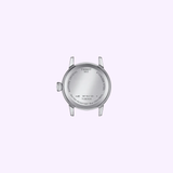 The back of a Tissot Watches Classic Dream 28mm T1292101105300 women’s stainless steel watch case in silver, featuring engraved details like water resistance, serial numbers, and the Tissot Watches logo, set against a light lavender background.