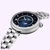 Tissot Watches Desir T1522231149600 silver-tone watch featuring a dark blue glitter dial, diamond hour markers, and a moon phase display on a link bracelet.