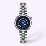 Tissot Watches Desir T1522231149600 watch with a silver link bracelet, a sparkling dark blue dial, diamond hour markers, and a moon phase indicator.