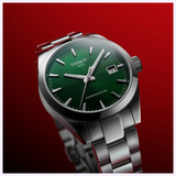 The Tissot Watches Gentleman 38mm T1658071109100, featuring a stainless steel band and green dial with date display and silver hour markers, is shown on a red gradient background with "TISSOT 1853" and "POWERMATIC 80" on the dial.