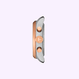 Side view of the Tissot Watches PR 100 36mm T1502172211100 case by Tissot Watches, featuring rose gold buttons and crown, with a blend of silver and rose gold tones, set against a pale lavender background.