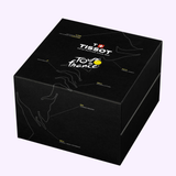 Black Tissot Watches PR 100 Tour de France 2026 40mm T1504173705700 box featuring minimalist white line art of hands and striking yellow highlights, with branded logos and labeled details on the lid and sides—expertly crafted to showcase the precision Swiss Quartz movement inside the Tissot Watches PR 100 Tour de France 2026 chronograph.