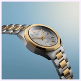 Showcasing timeless sophistication, the Tissot Watches PRC 100 Solar 34mm T1518222203100 features a striking two-tone metal bracelet in silver and gold with a matching gold bezel. Its refined silver dial is accented by gold hour markers and includes a convenient date display, all powered by Swiss quartz solar technology for precise timekeeping. Set against a soft blue gradient background, this classic Tissot Watches model combines elegance and innovation in its 34mm stainless steel design.