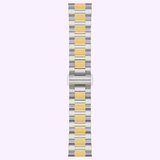 A two-tone metal watch band with alternating silver and gold links is displayed from above against a light purple background. The clasp at the center features the Tissot Watches engraving, perfectly complementing the elegant design of the 34mm stainless steel Tissot Watches PRC 100 Solar T1518222203100.