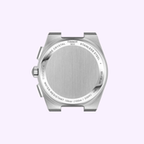 A stainless steel case back from the Tissot Watches PRX 41mm T1374171105100 chronograph, featuring engraved text highlighting its sapphire crystal, 10 bar (100m/330ft) water resistance, and model details. This Swiss quartz chronograph by Tissot Watches is set against a light purple background.