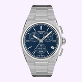 The Tissot Watches PRX 41mm T1374171105100 features a stainless steel case, a blue dial with three subdials and silver hour markers, and a metal bracelet. This Swiss quartz chronograph wristwatch by Tissot Watches is displayed against a light purple background.